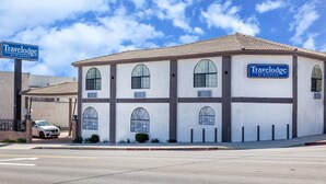 A Travelodge by Wyndham with a two-story structure, large arched windows, and a tiled roof. - Travelodge by Wyndham Harbor City (Harbor City)
