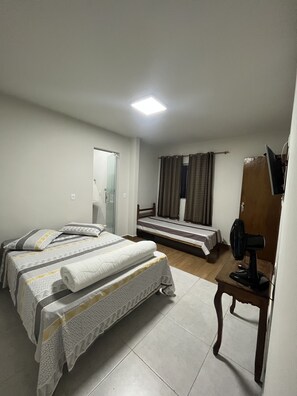 Minibar, escritorio, cortinas blackout y tabla de planchar con plancha