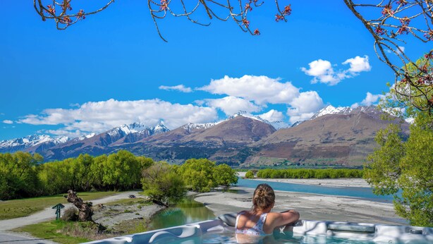 A woman relaxing in a hot tub with a mountain view. - EcoScapes (Kinloch)