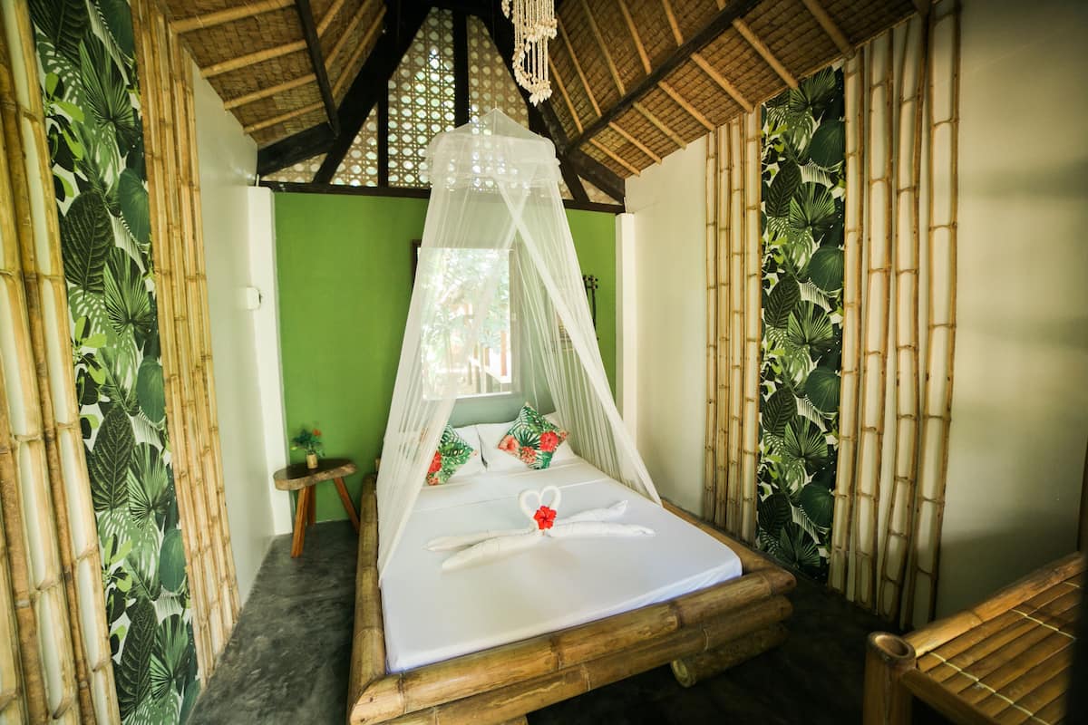 Una habitación con una cama, una mesita y una silla.