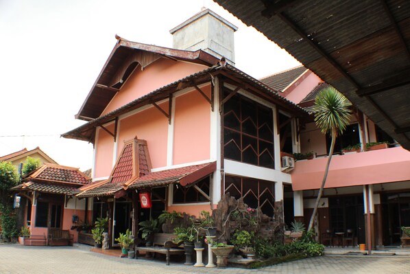 A traditional building with a tiled roof, large windows, and potted plants. - Ananda Hotel (Yogyakarta)