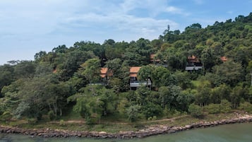 A hillside property with multiple buildings surrounded by dense forest.