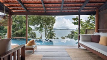 A covered outdoor seating area with a view of a lake and mountains.