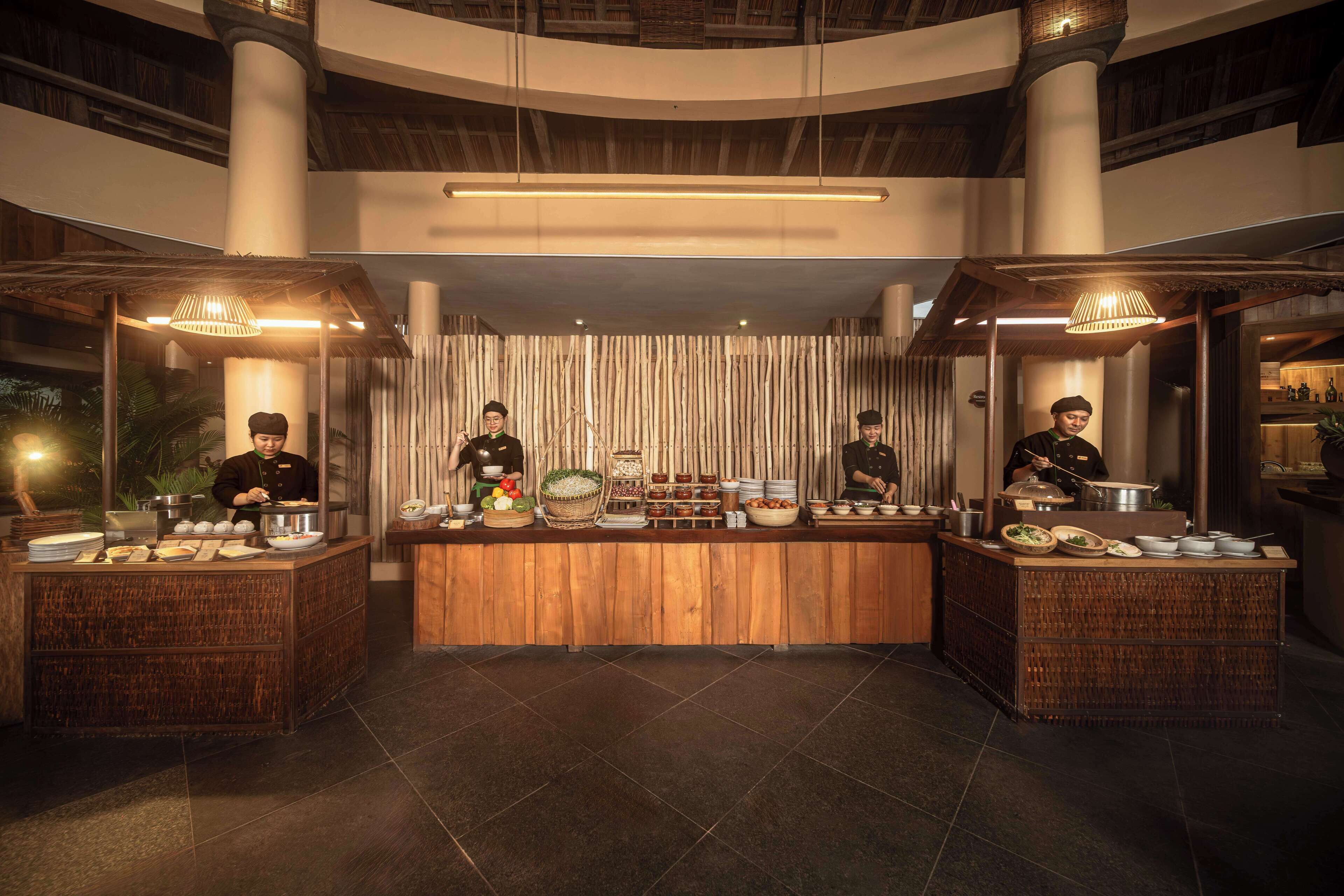 A buffet setup with multiple serving stations, each with a variety of dishes and a staff member attending to it.