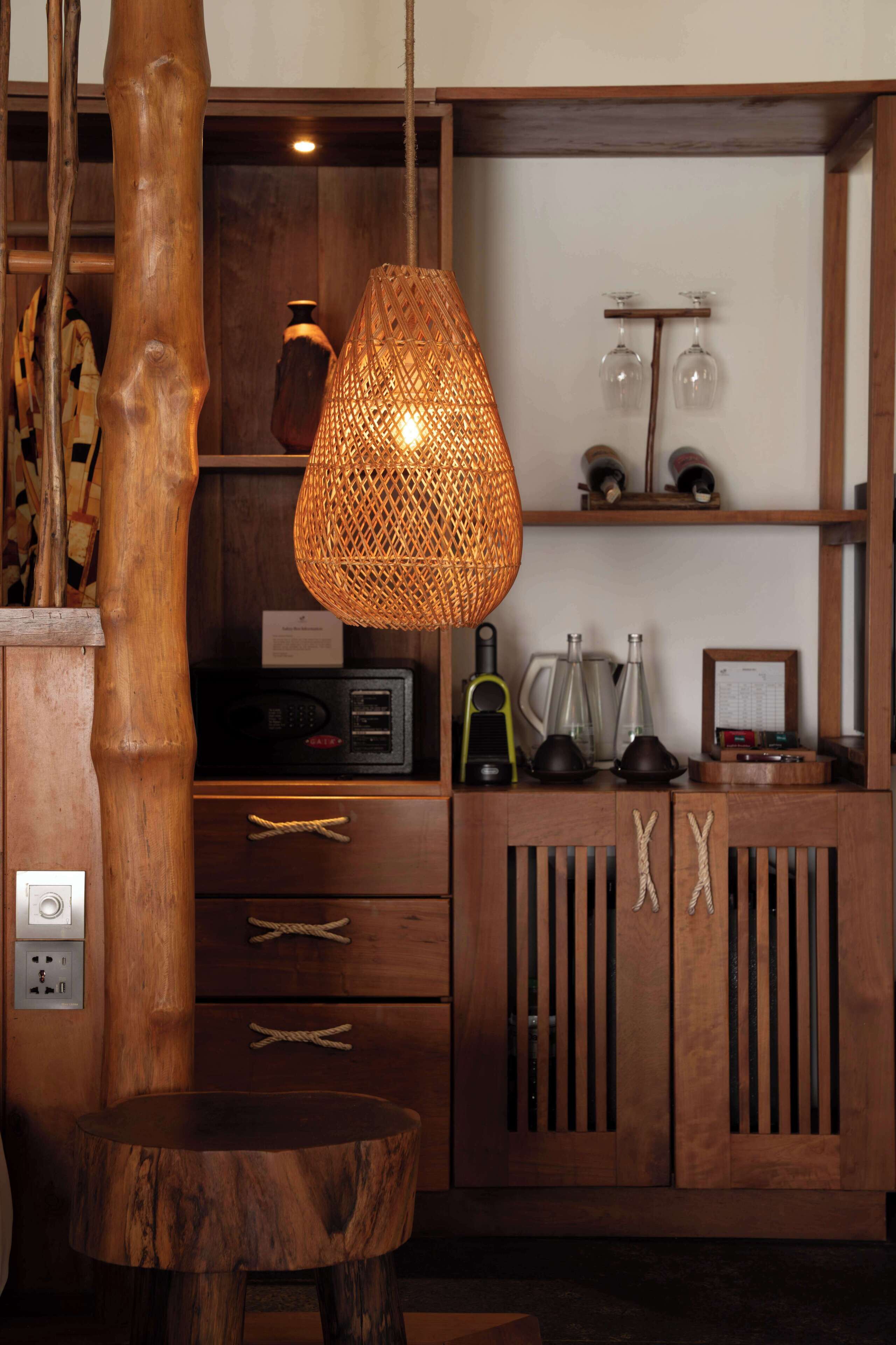 A wooden cabinet with drawers, a woven pendant light, and a small table.