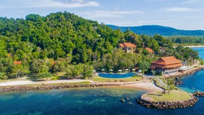 A coastal resort with a swimming pool, beach, and forested hills. - Green Bay Phu Quoc Resort & Spa (Phu Quoc)