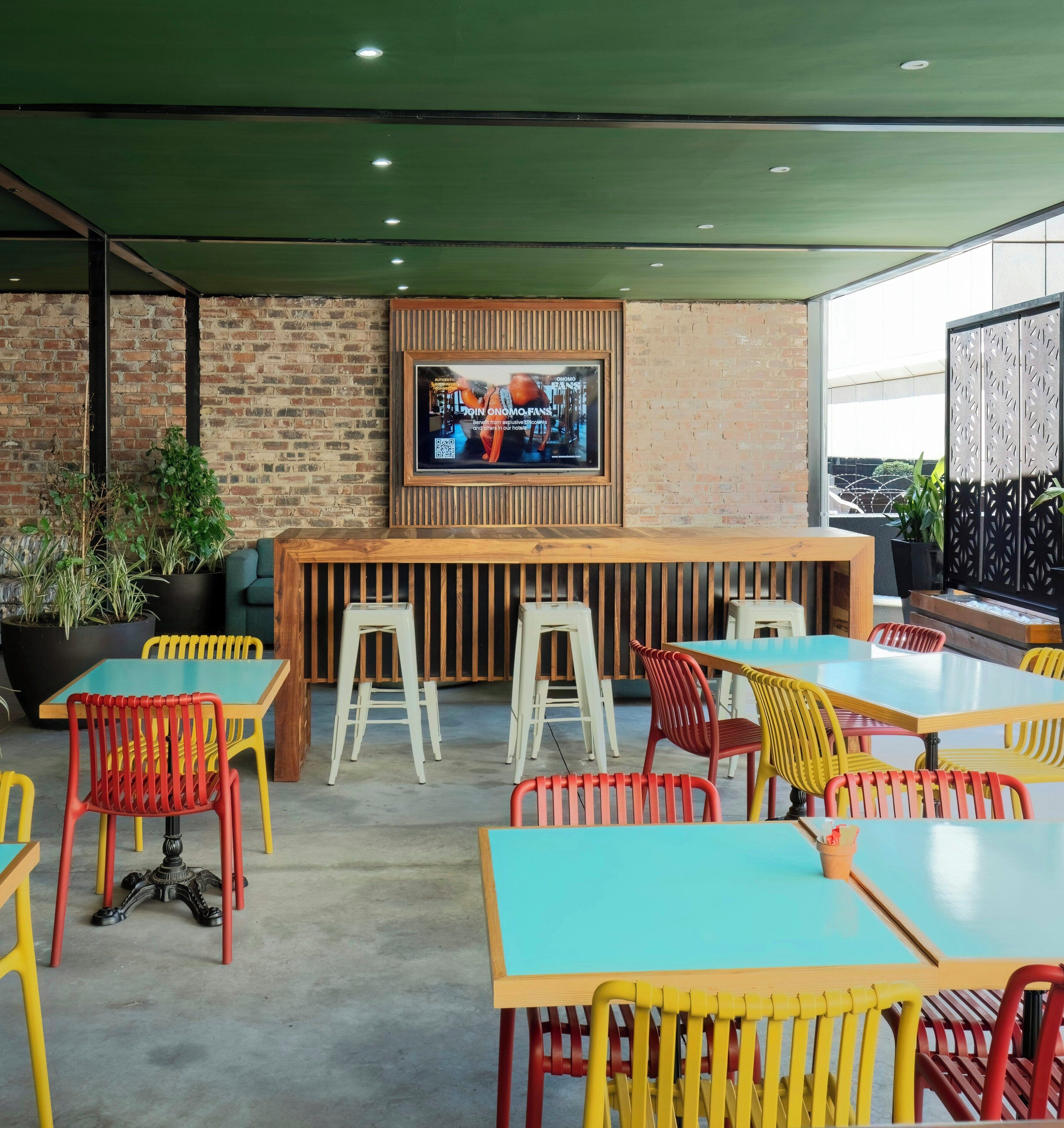 Un espace de détente intérieur moderne, avec un mur en briques, un bar en bois et un écran de télévision.