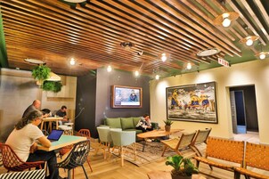 Un interior moderno con techos de listones de madera, zonas de estar y una pantalla de televisión.