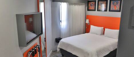 Una habitación de hotel con dos camas, televisión, escritorio y baño.