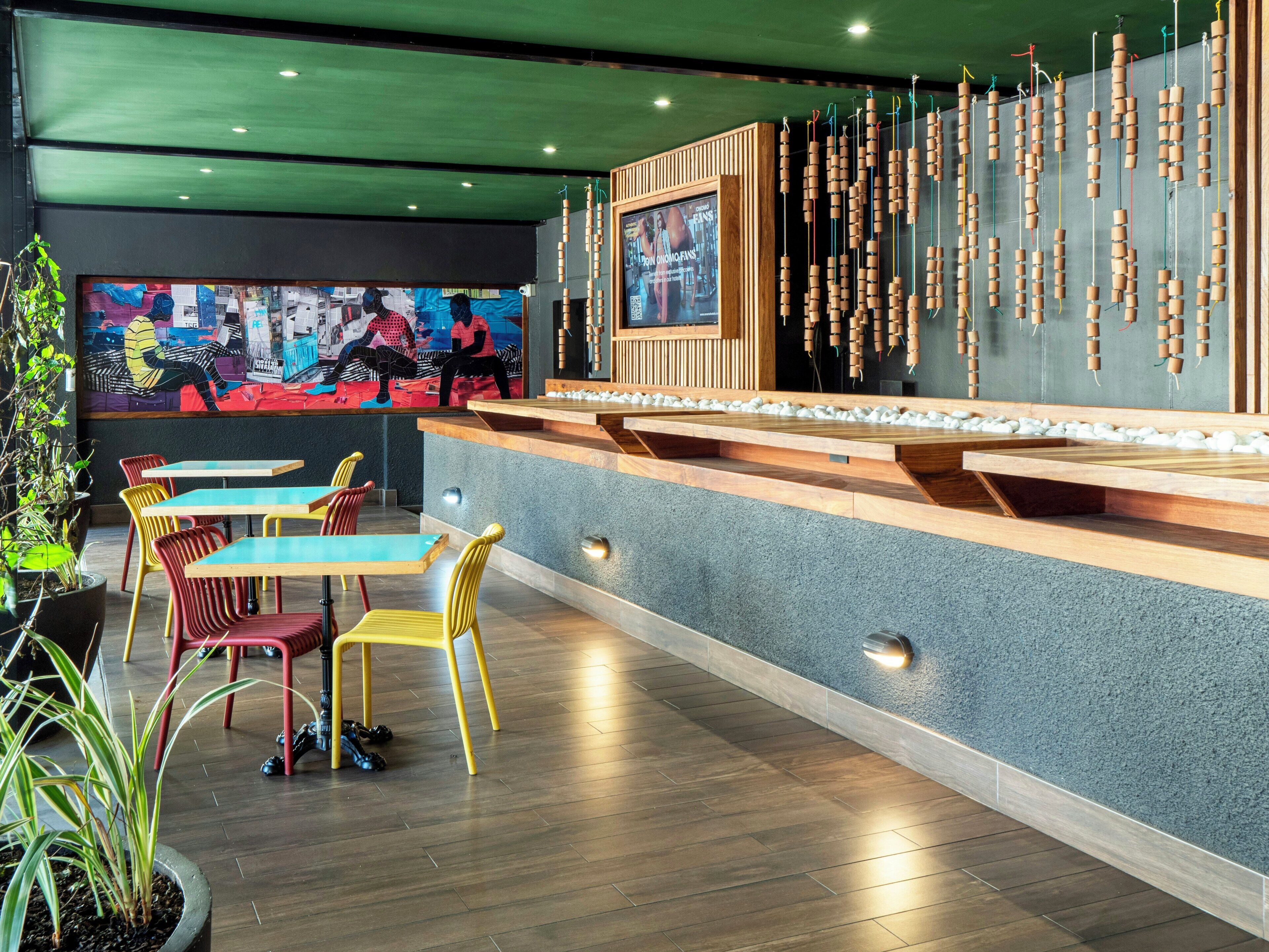 A restaurant interior with a counter, seating area, and a wall-mounted television.