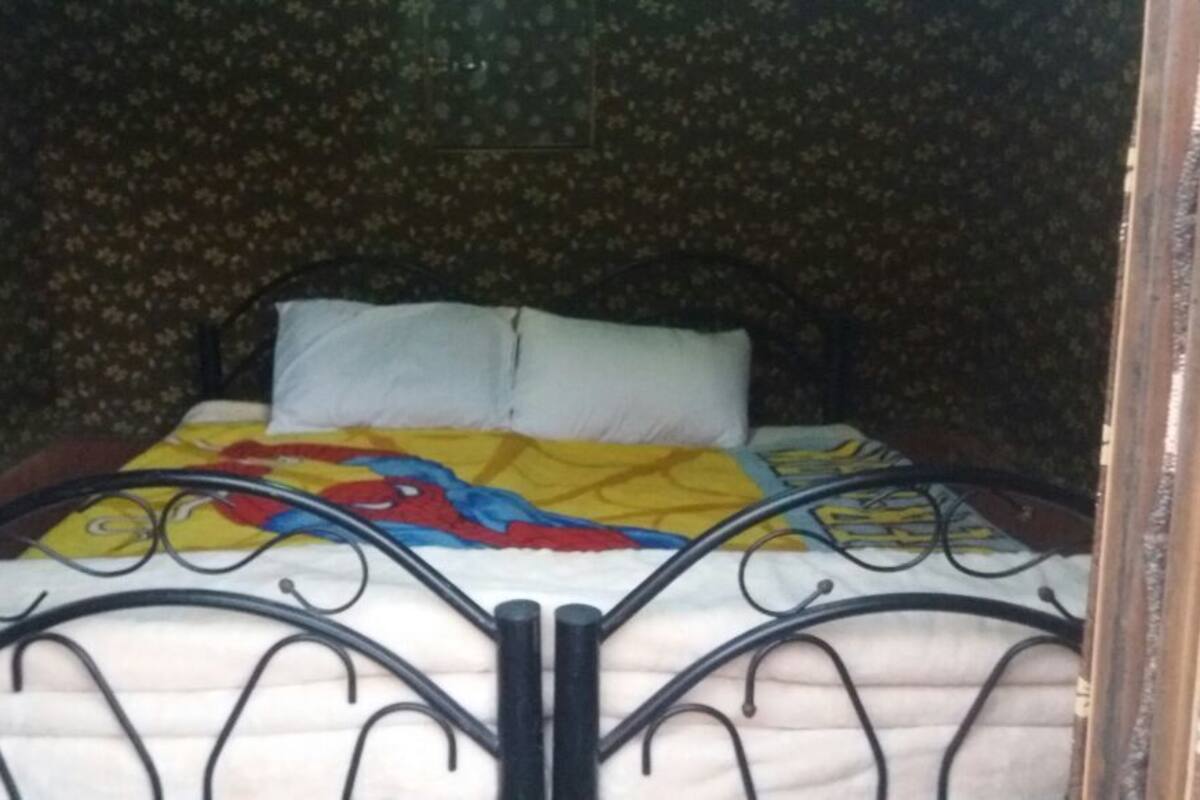 A bed with a floral-patterned headboard and a colorful blanket.