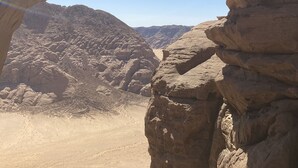 A person jumping through a natural rock arch formation. - Wadi Rum Sky (Wadi Rum)