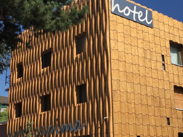 A hotel facade with vertical wooden slats and a sign that reads "hotel".