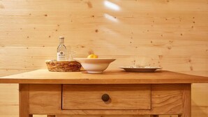 A wooden table with a bottle, a bowl, and a plate. - Hotel Capima (Cologne)