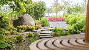 Un sendero en el jardín con piedras que guían hasta una zona de estar.