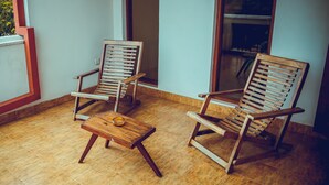 Two wooden chairs and a small table on a tiled floor, with a window and a door in the background. - The Terranova Inn (Negombo)