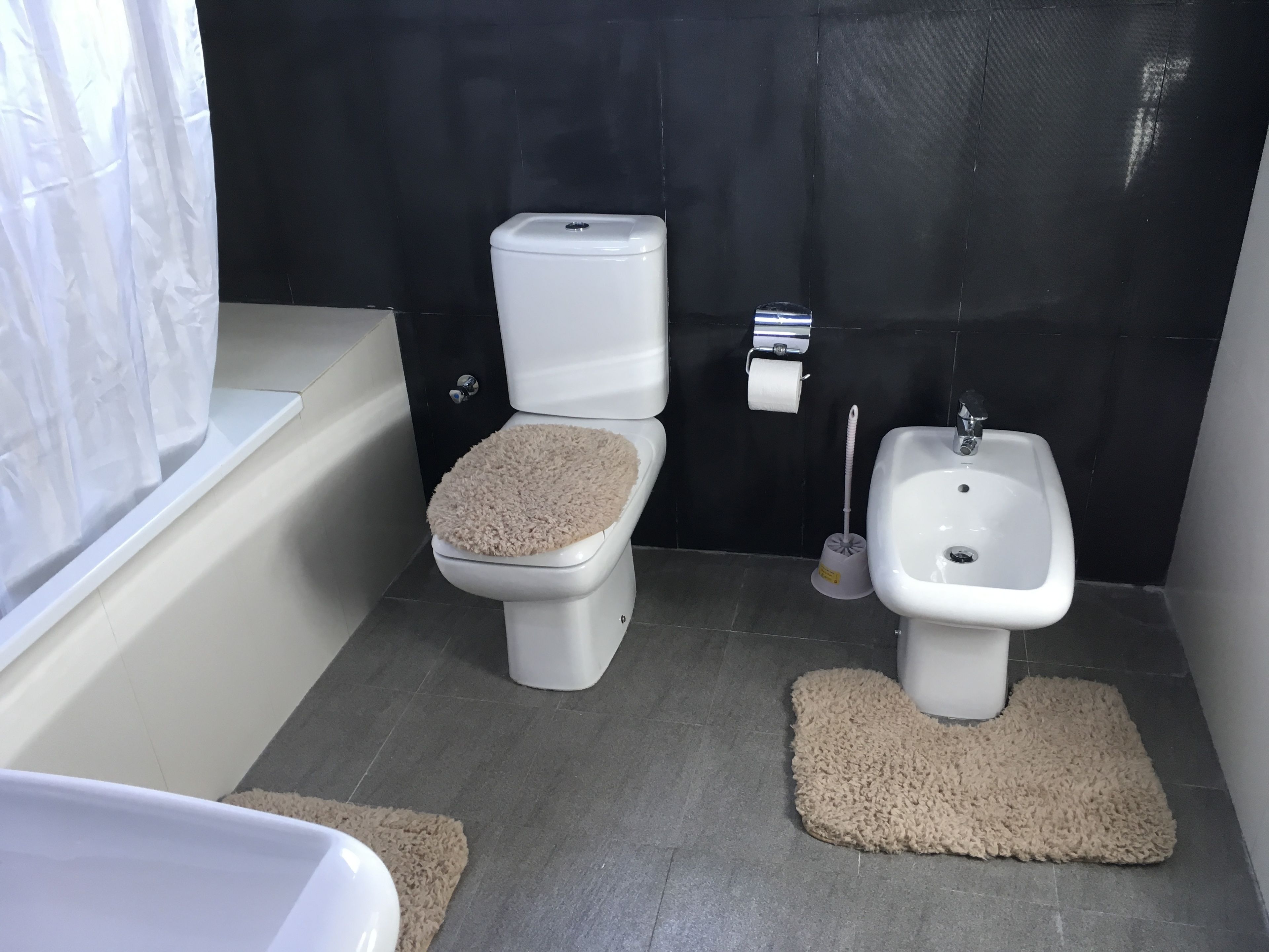 Un baño con inodoro, bidé y bañera.