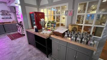 Una cocina con un electrodoméstico rojo, una cafetera y diversos utensilios de cocina.