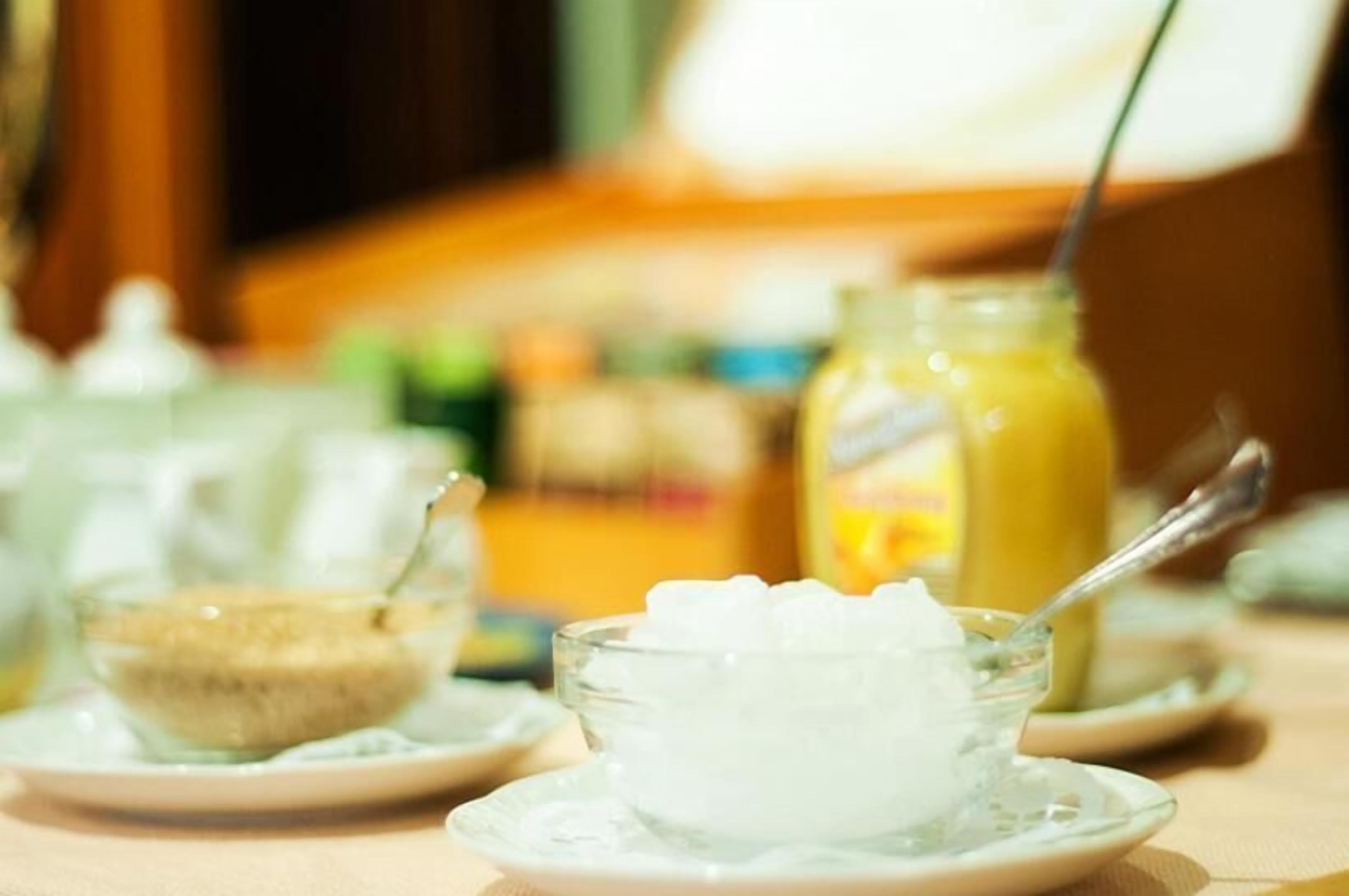 A table with a bowl of ice cream and a glass of orange juice.