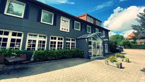 A hotel with a sign indicating it is a 'hafen hotel' and has a glass entrance. - Hafen Hotel Schützenhof (Fehmarn)