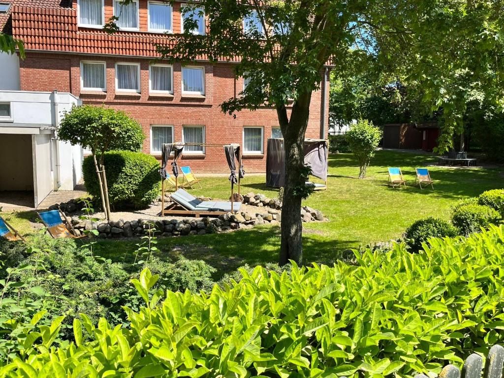Un edificio residencial con fachada de ladrillo, césped cuidado y zona de estar al aire libre.