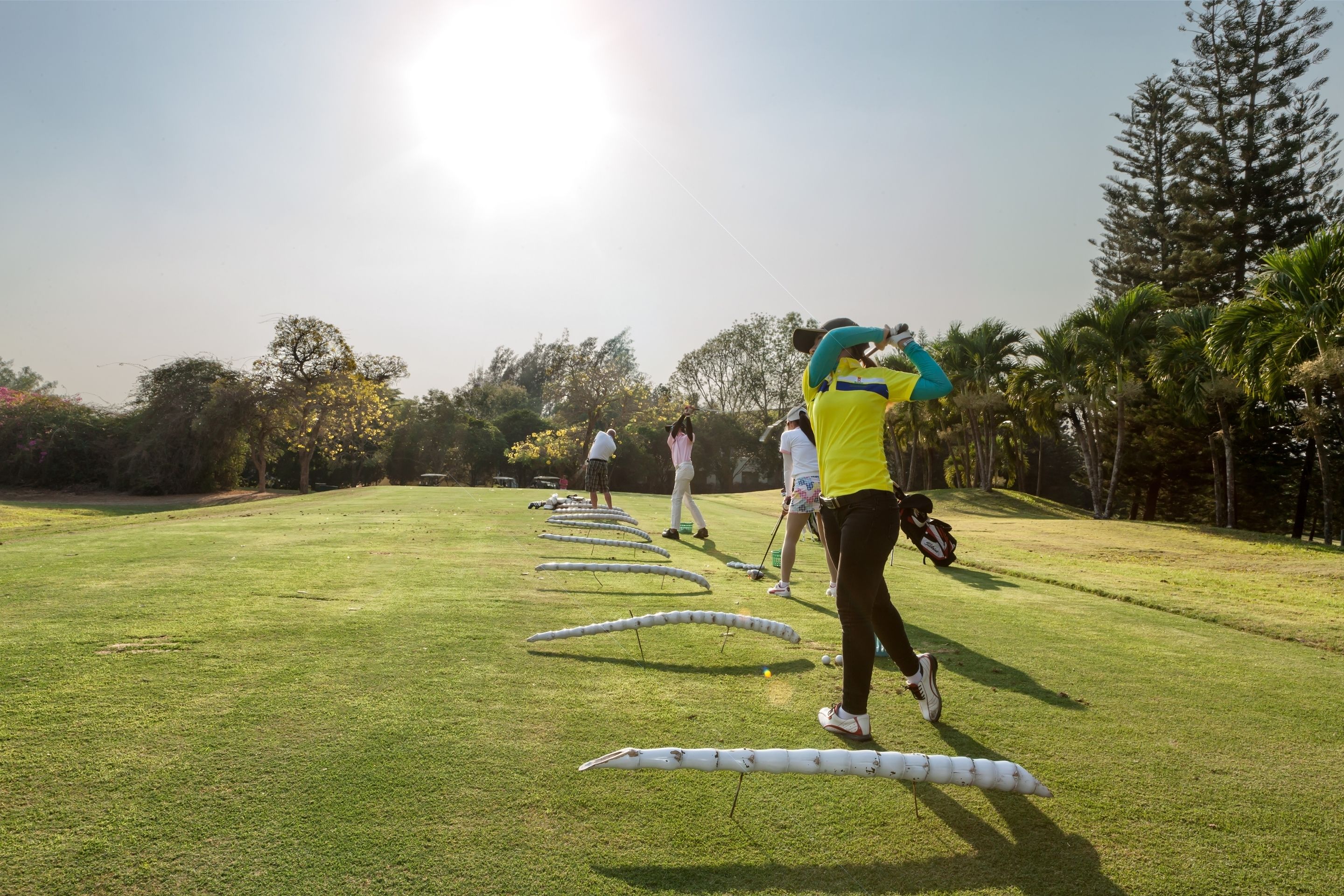 Un campo de golf con jugadores practicando sus golpes.
