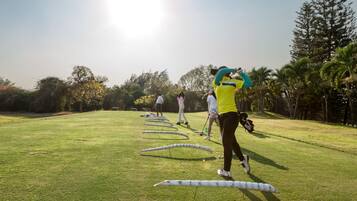 Un campo de golf con jugadores practicando sus golpes.