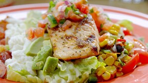 A plate with grilled fish, avocado, lettuce, and a colorful vegetable salad. - End Glory Hotel (Corlu)