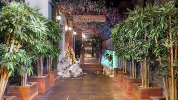 Un sendero de madera que lleva a la entrada de un edificio con un letrero que dice 'Rozmarin'.