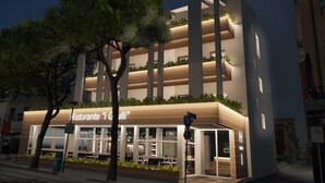 Il s’agit d’un bâtiment moderne qui abrite un restaurant appelé « Ristorante ‘Giulio’ ». Il se distingue par sa structure à plusieurs étages, ses balcons et sa façade bien éclairée.