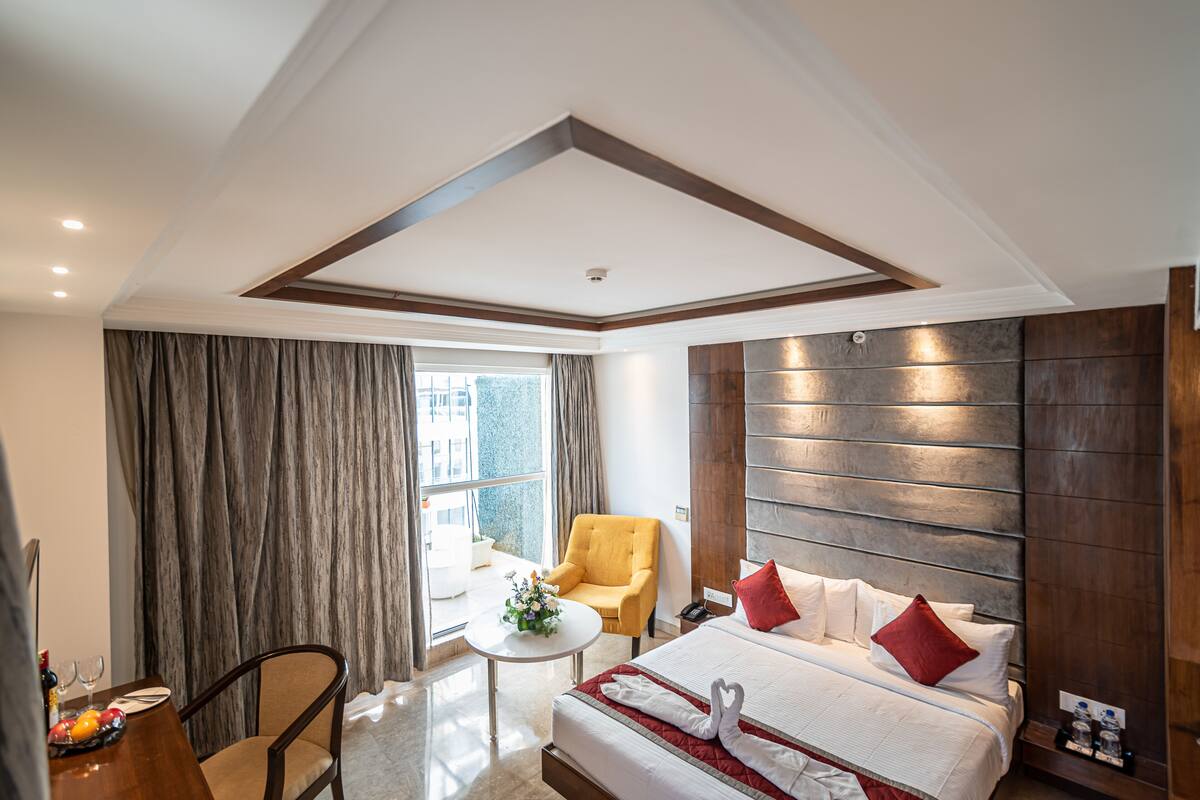 Una habitación de hotel con cama, una silla, una mesita y una ventana.