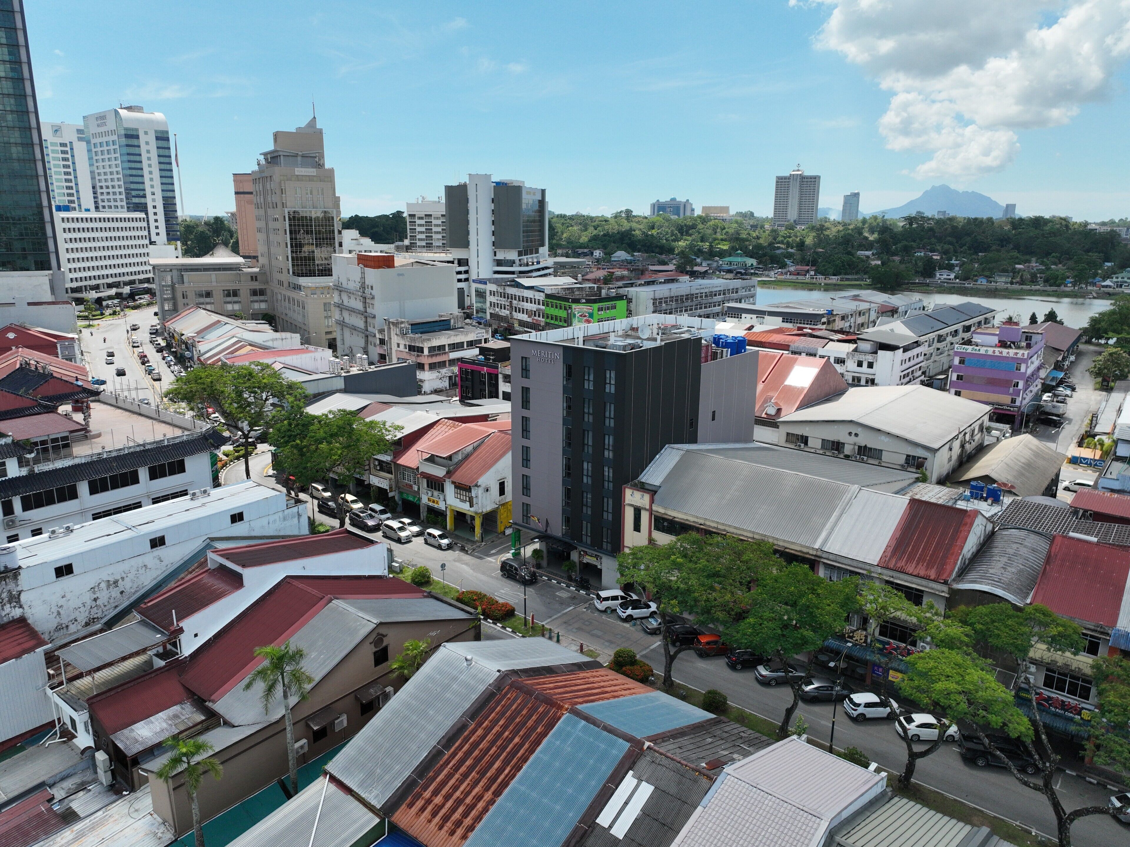 A cityscape with various buildings, including a prominent hotel with a modern design and multiple floors.