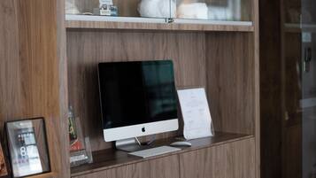 A wooden display shelf with a computer monitor, keyboard, and a menu sign.