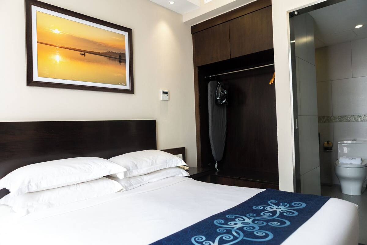 Una habitación de hotel con cama, ducha y retrete.