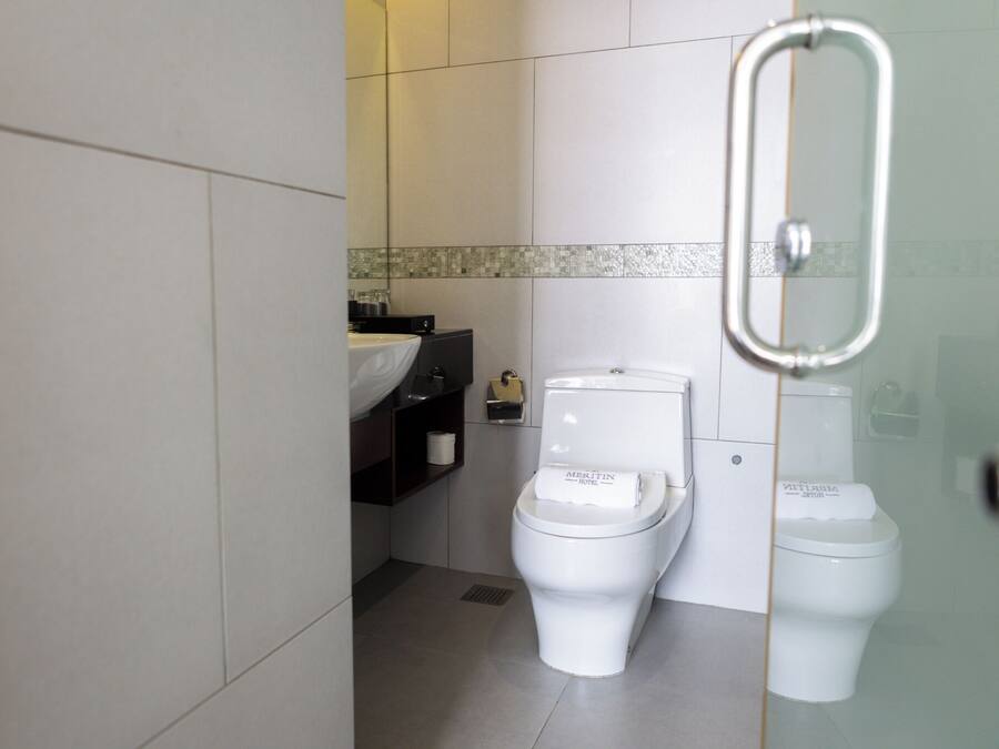 A bathroom with two toilets, a sink, and a mirror.