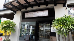 The exterior of the Meritin Hotel with a clear entrance, a covered walkway, and potted plants. - Meritin Hotel (Kuching)