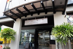 The exterior of the Meritin Hotel with a clear entrance, a covered walkway, and potted plants. - Meritin Hotel (Kuching)