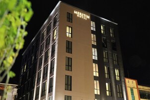 Un edificio de hotel de varios pisos con un cartel que dice 'Meritin Hotel'.