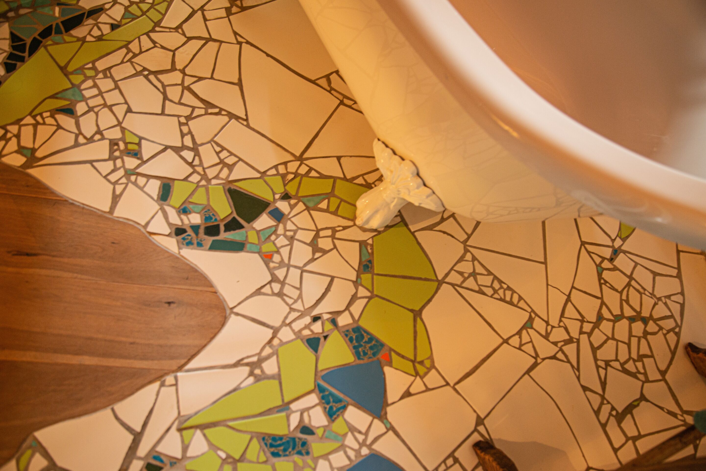Un suelo de mosaico con una mesa de madera parcialmente visible.