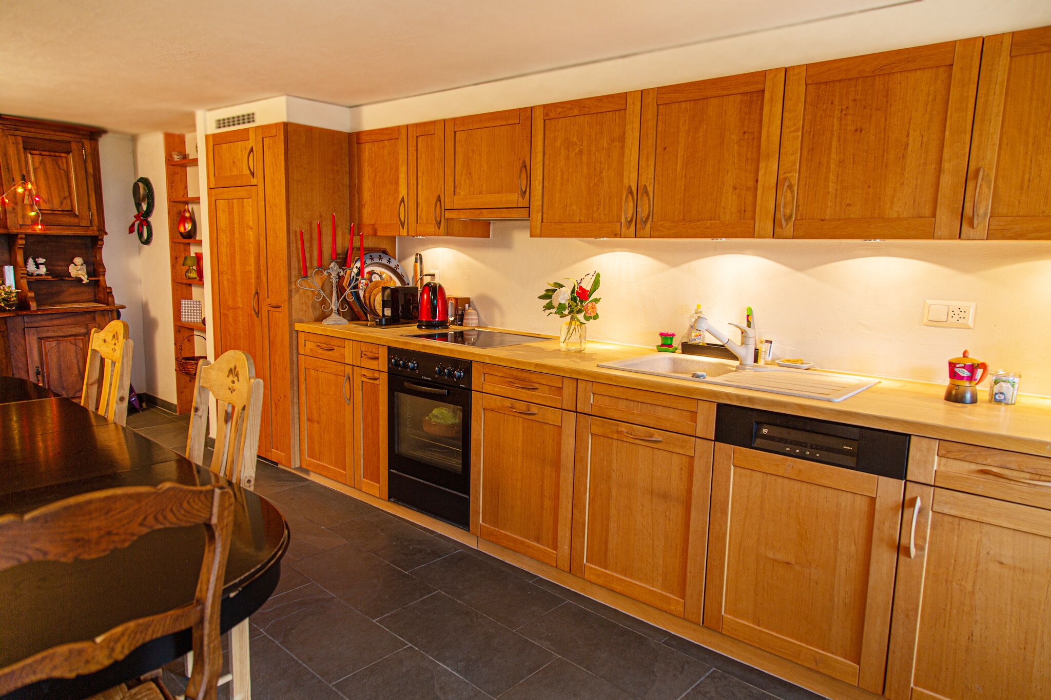 A kitchen with wooden cabinets, a stove, oven, and dishwasher.