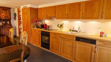 A kitchen with wooden cabinets, a stove, oven, and dishwasher.