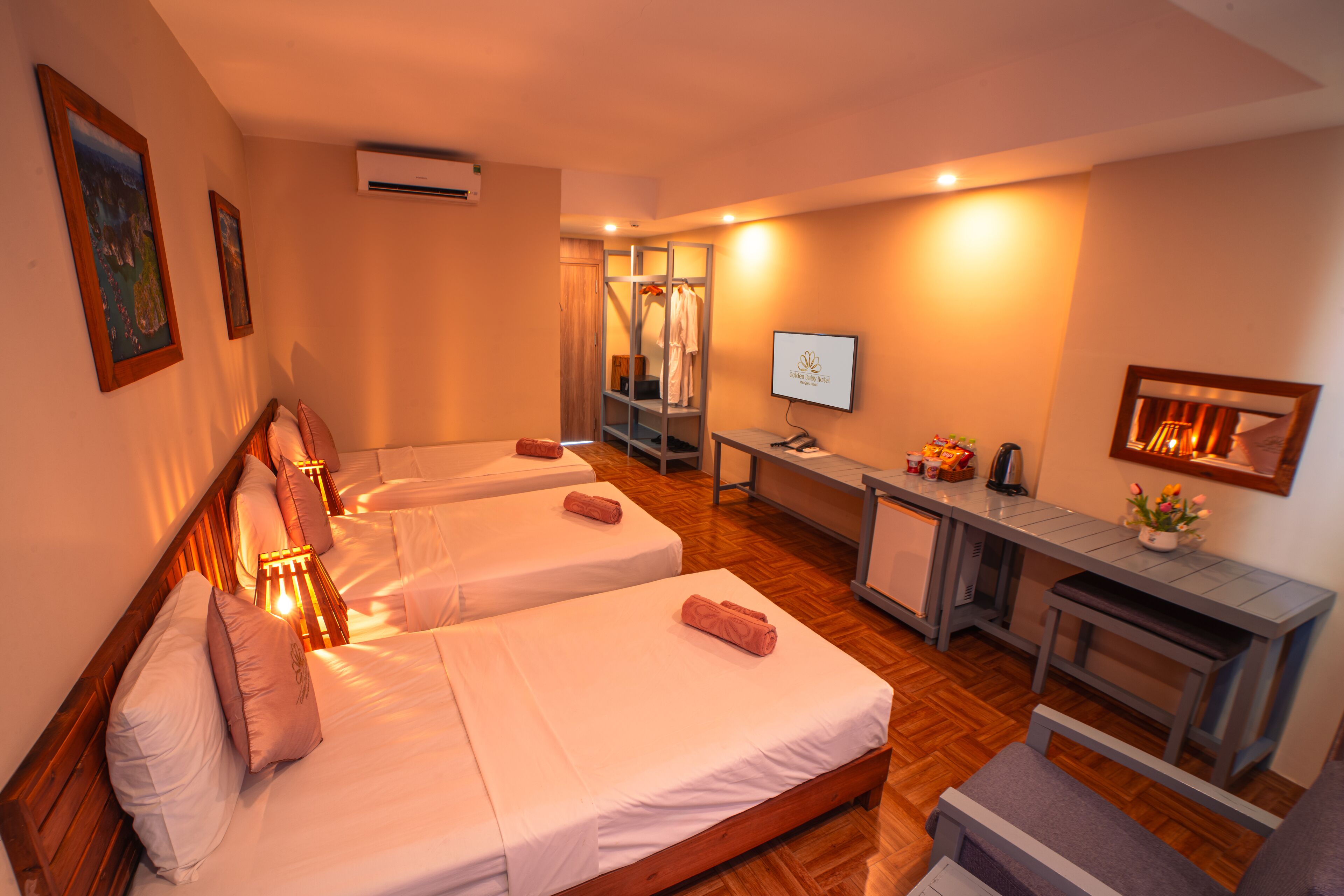 A hotel room with two beds, a desk, a mirror, and a TV.
