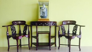 Une pièce comprenant deux fauteuils richement décorés et une petite table sur laquelle est posé un objet décoratif.