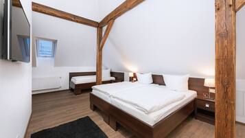 Une chambre à coucher avec un grand lit, deux tables de chevet, une télévision et une fenêtre.