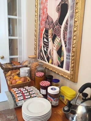 A breakfast buffet with various food items, a painting, and kitchenware. - Villa Bougenvilia Tomas (Tucepi)