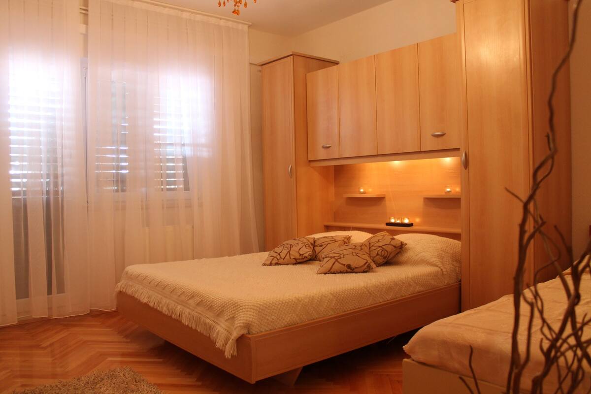 Un dormitorio con cama de madera, mesita de noche y armario.