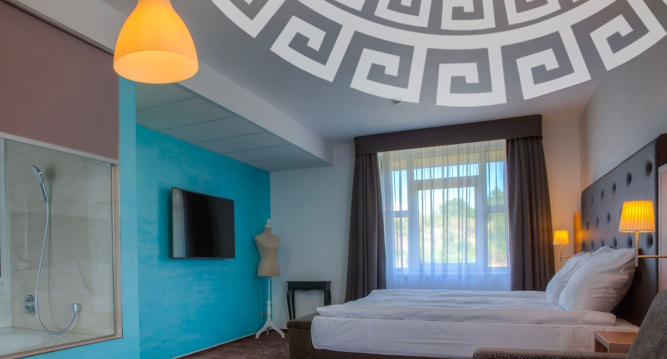 Habitación de hotel con una cama grande, televisión, ducha y vistas al exterior.