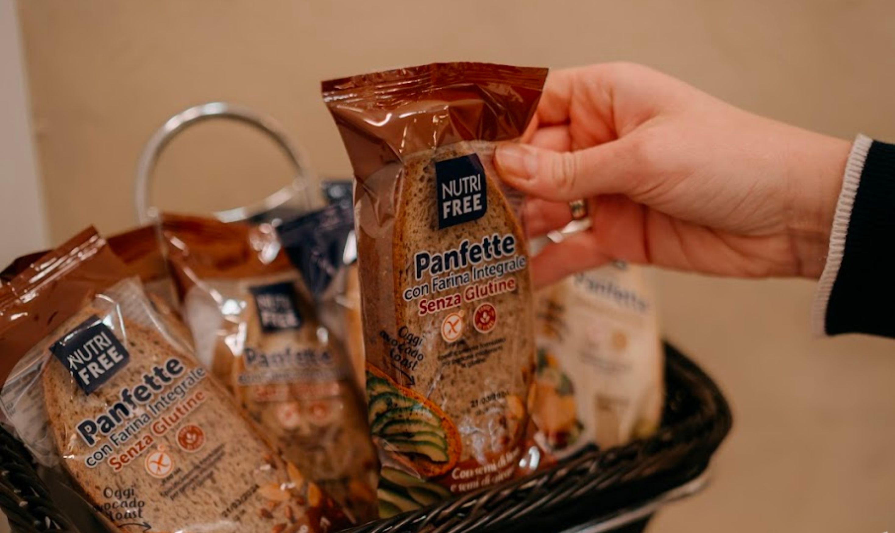 Una mano sostiene una bolsa de pan sin gluten con la etiqueta 'NUTRI FREE' de Panettone.