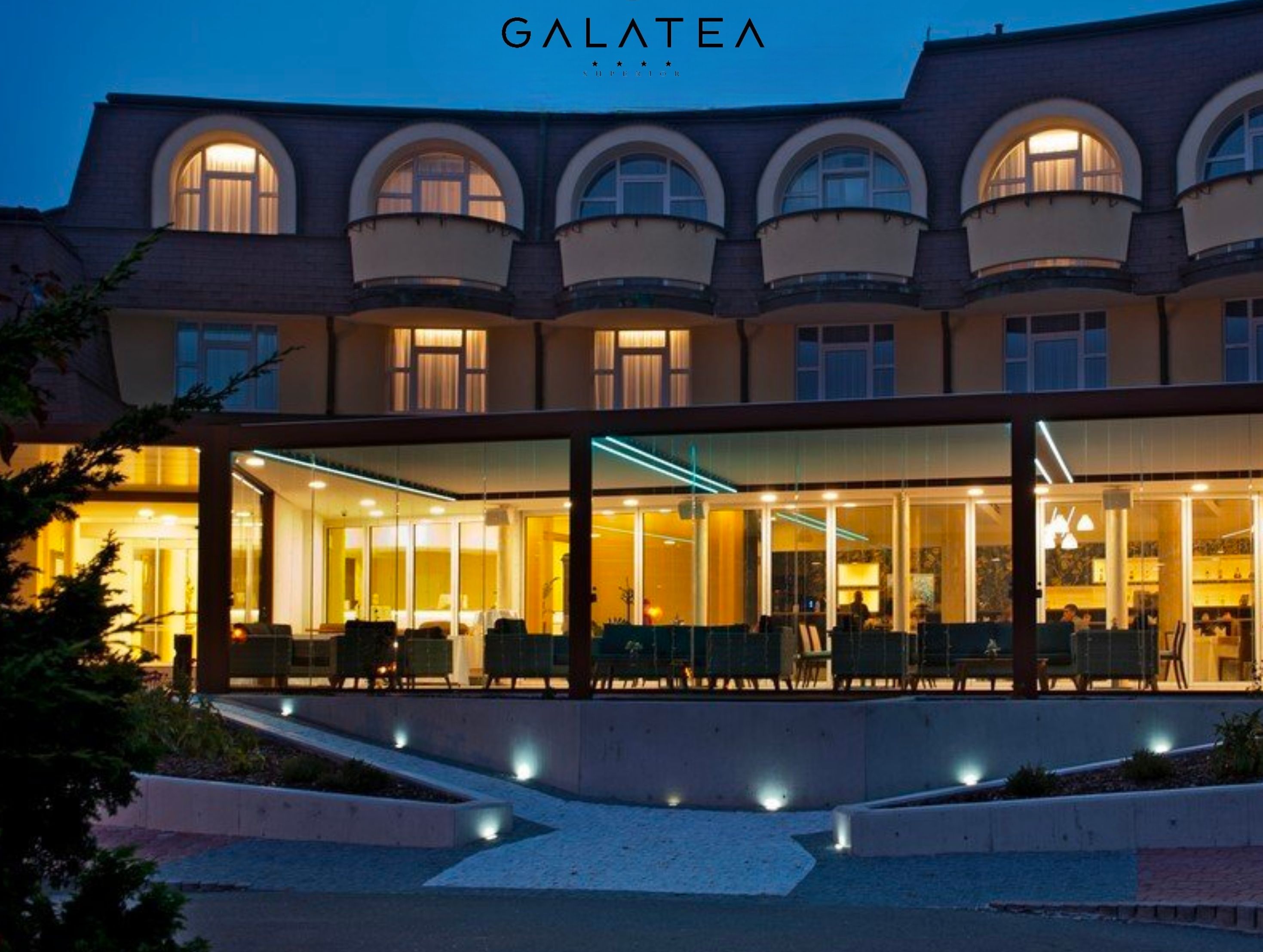 A hotel with a modern facade, large windows, and a well-lit interior.