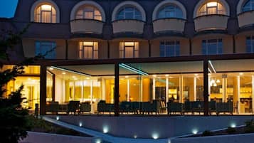 A hotel with a modern facade, large windows, and a well-lit interior.